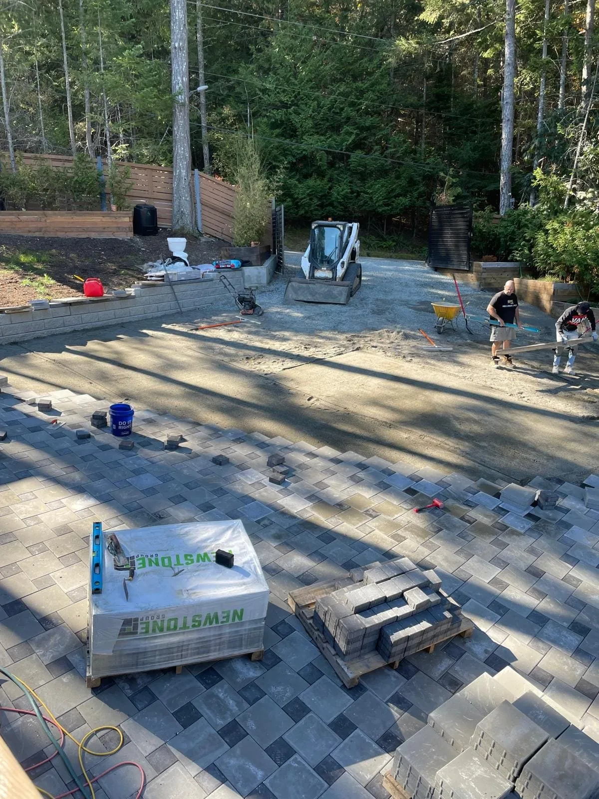 Crew laying pavers over a compacted base