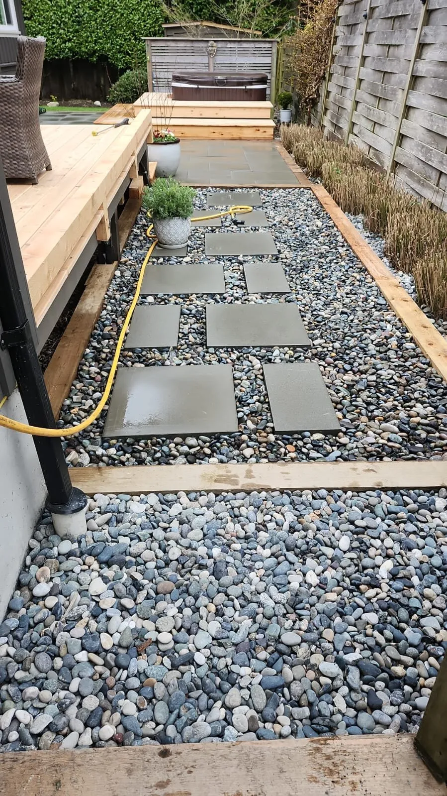 Slab patio and drainage rock alongside a new deck
